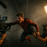 Young male actor in red and blue Spider-Man costume performing dangerous stunt