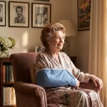 An elderly woman in her 80s with resting comfortably in a luxurious living room with her right arm in a medical sling
