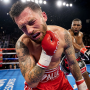 A professional boxer in the ring clutching his jaw in pain after receiving a heavy punch during a match