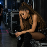 Female pop singer sitting backstage exhausted after intense live concert performance