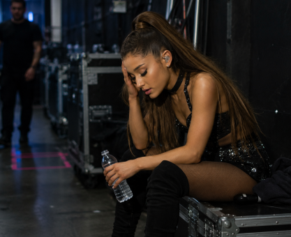 Female pop singer sitting backstage exhausted after intense live concert performance