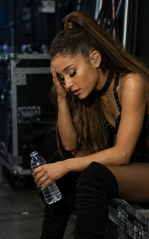 Female pop singer sitting backstage exhausted after intense live concert performance