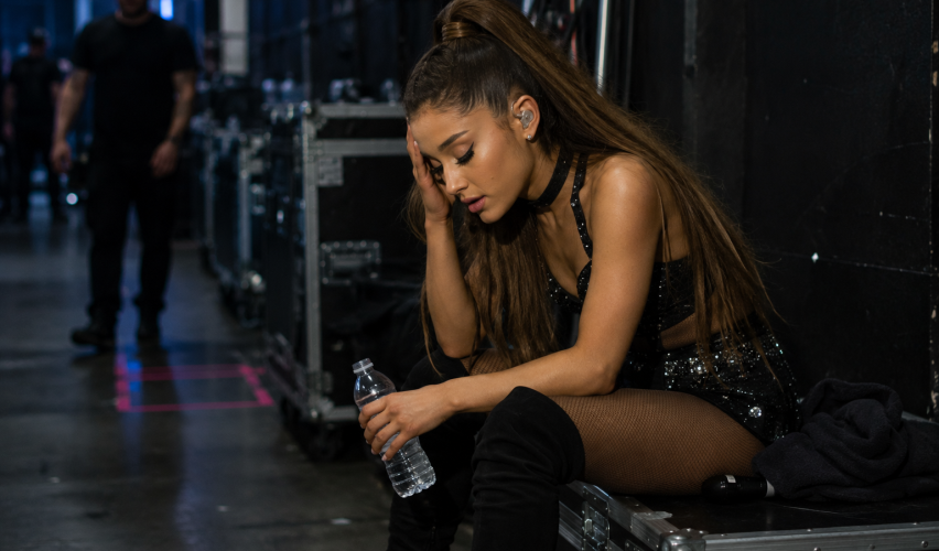 Female pop singer sitting backstage exhausted after intense live concert performance