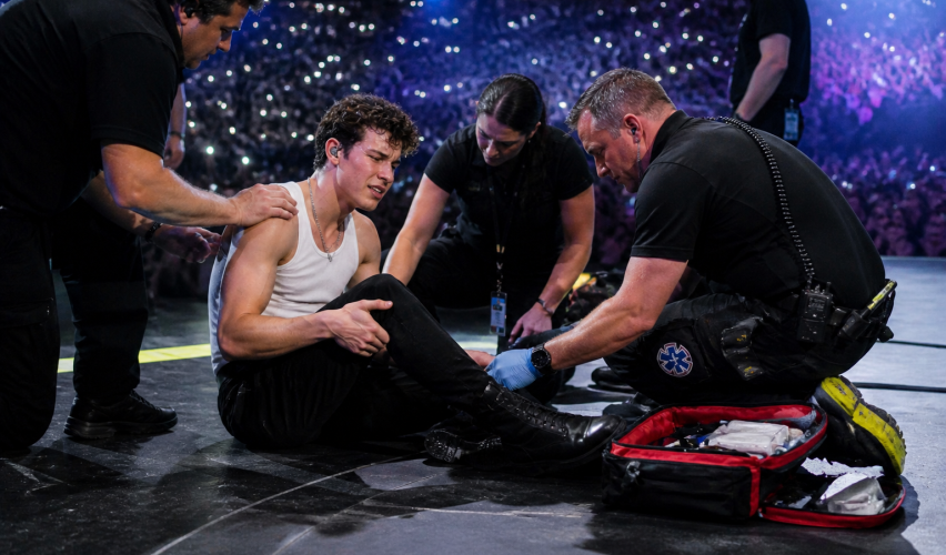 Singer receiving medical attention on stage during live performance