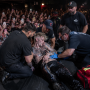 MGK Back Injury After Stage Dive Raises Concert Safety Concerns Male rock performer receiving medical attention after stage dive injury at a crowded club