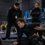 Actor performing action stunt rehearsal with safety crew after possible back injury concern