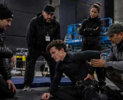 Actor performing action stunt rehearsal with safety crew after possible back injury concern