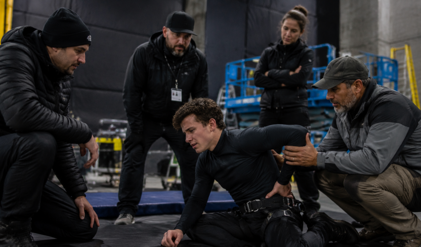 Actor performing action stunt rehearsal with safety crew after possible back injury concern