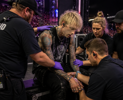 MGK receiving medical attention after stage dive at a live concert
